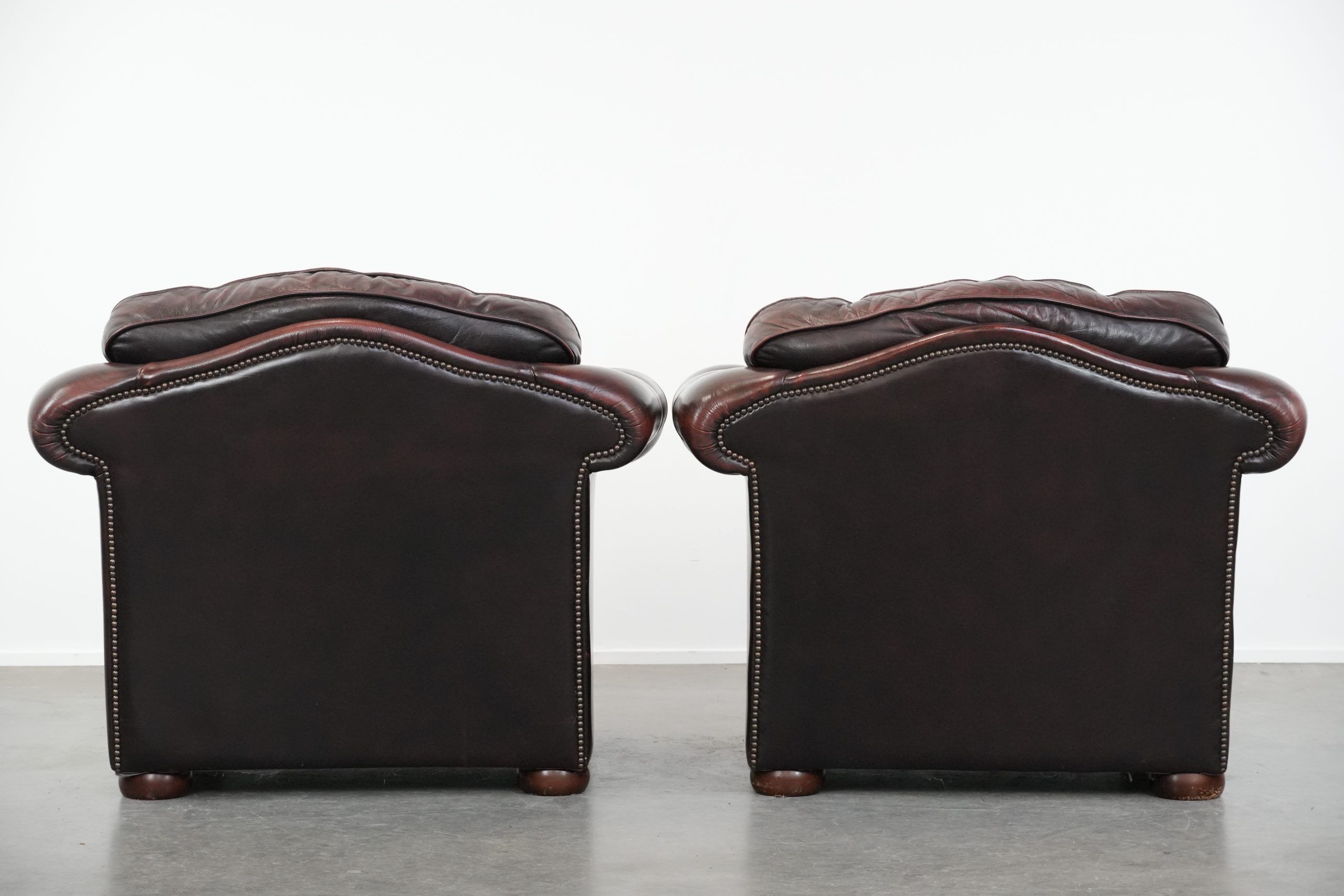 Set of two marbled cowhide leather Chesterfield armchairs in English style