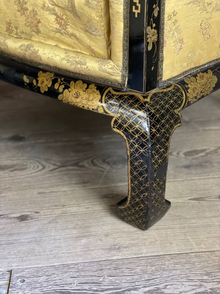 A set of two armchairs, a sofa and two poufs in lacquered wood with gilded chinoiserie decoration.