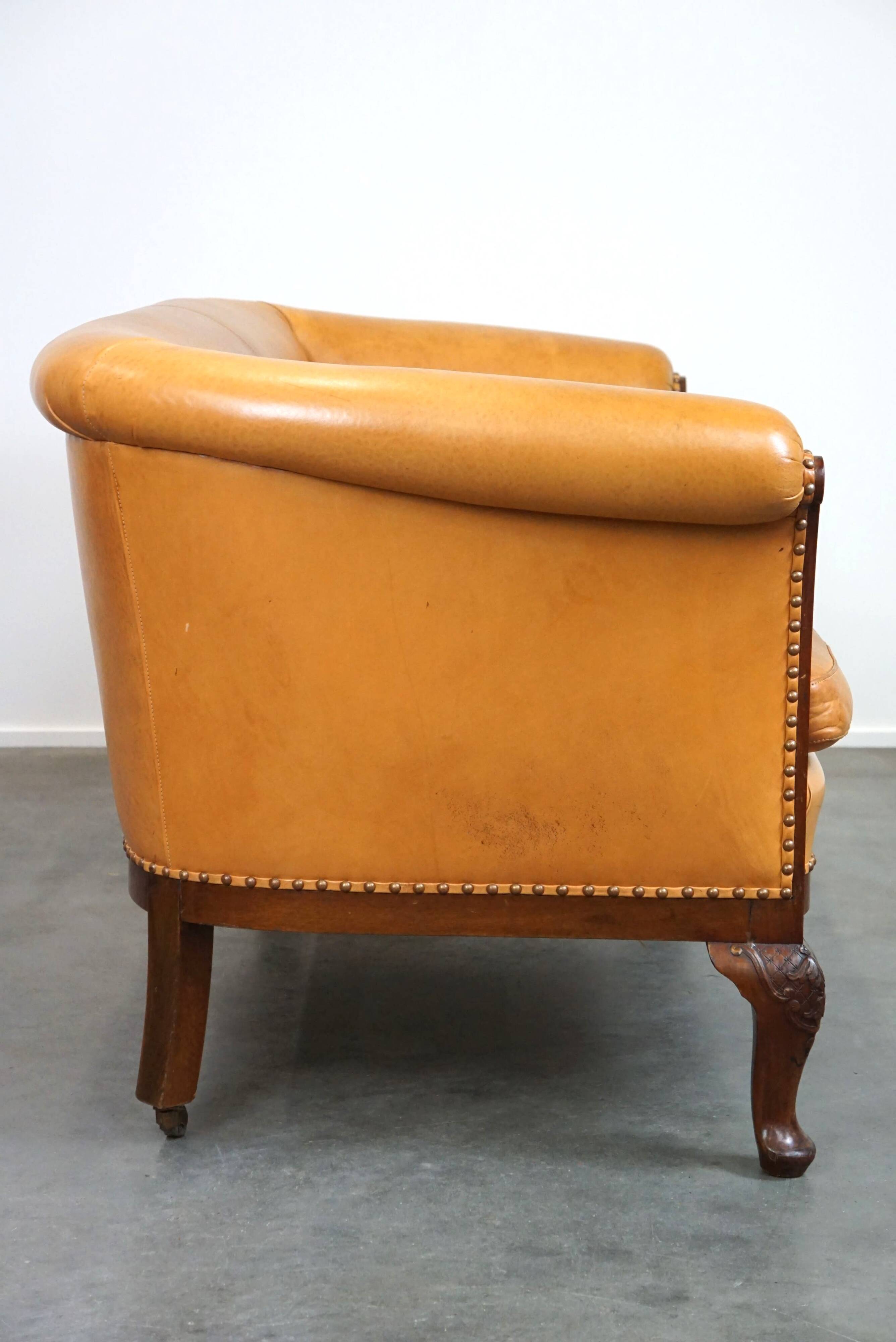 Unique old set of 2 club armchairs and a couch in cognac-colored leather with wheels