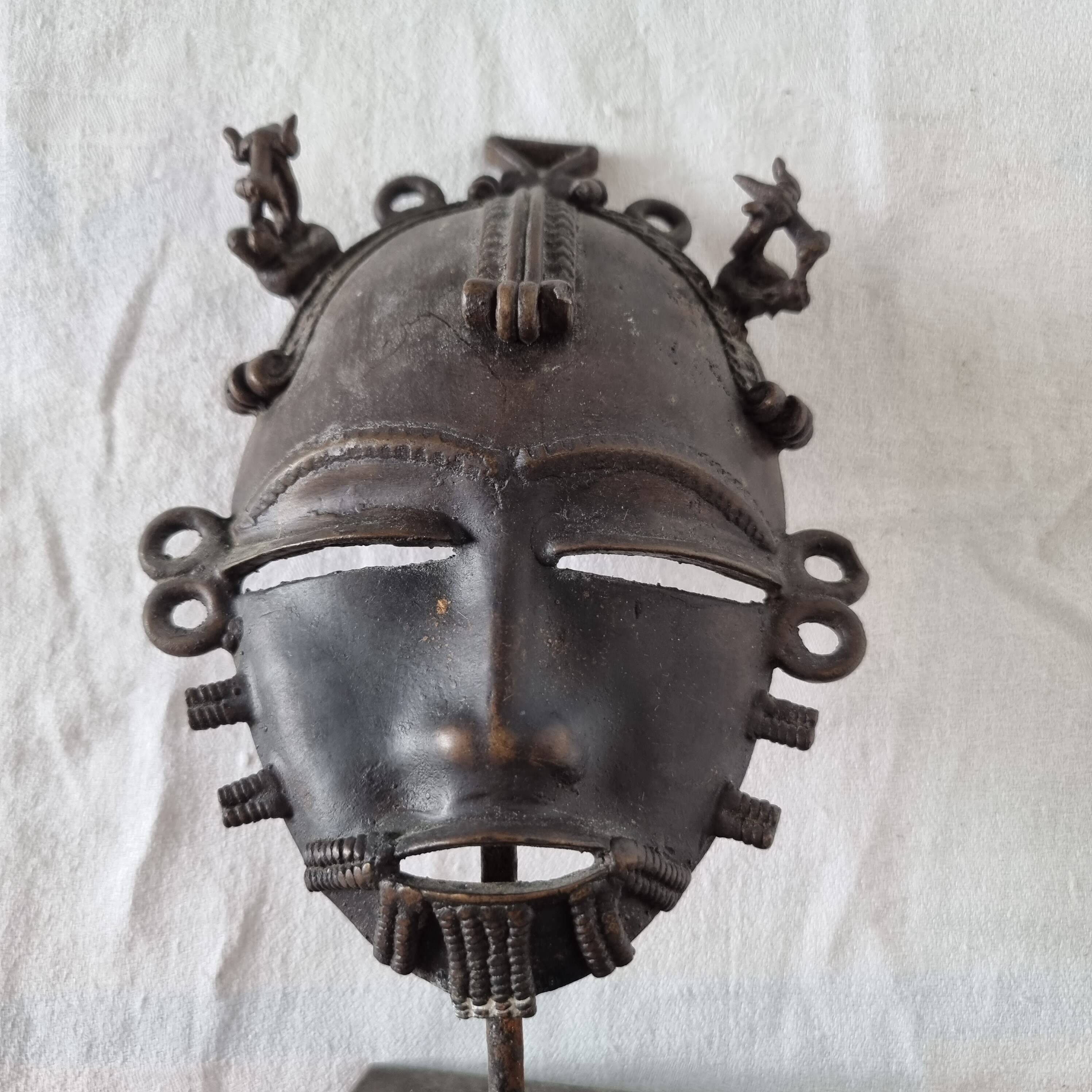 African bronze mask on pedestal, from Ivory Coast, dating