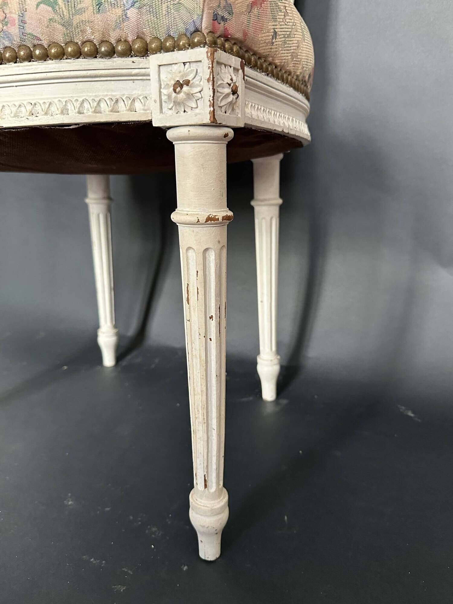 Antique Louis XVI style chair with patinated wood and floral fabric.