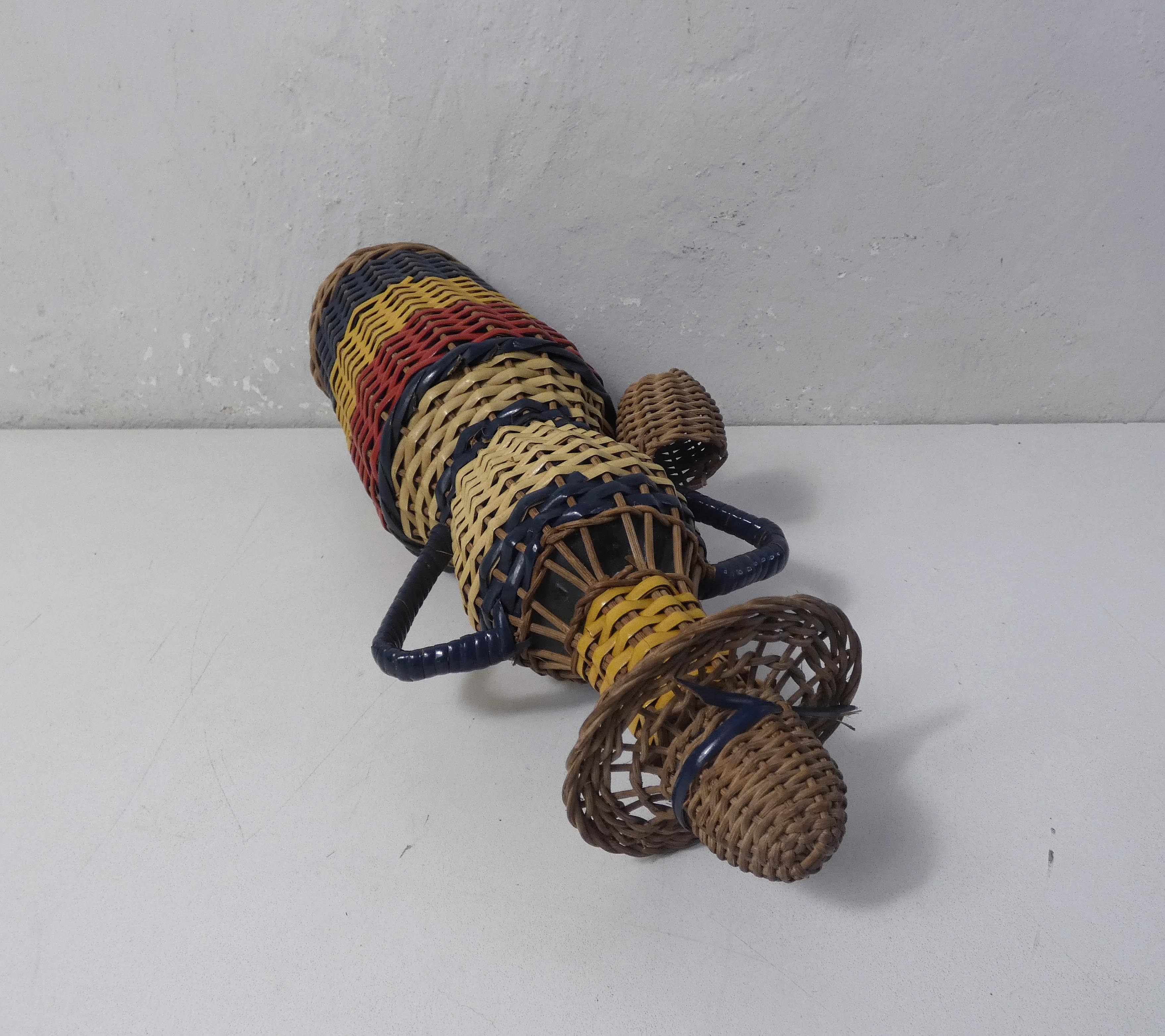 Old bottle dressed in scoubidou style rattan