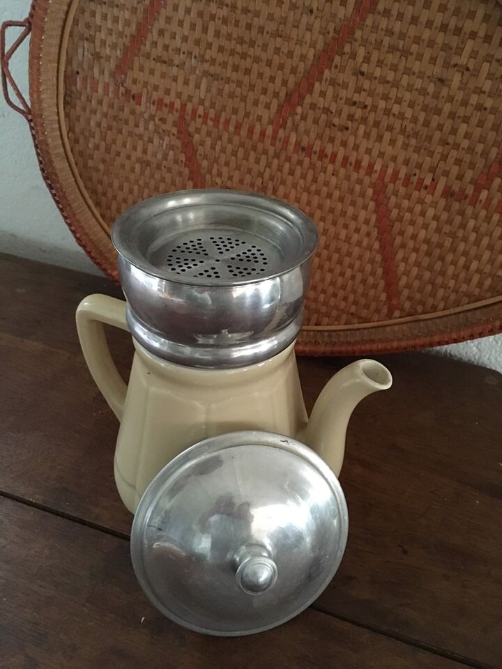 Old tea pot or coffee maker in faience cream with filter.