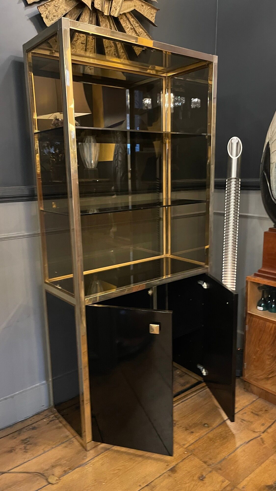 Hollywood Regency style bookcase shelf, gilded brass and black lacquered wood, 1970