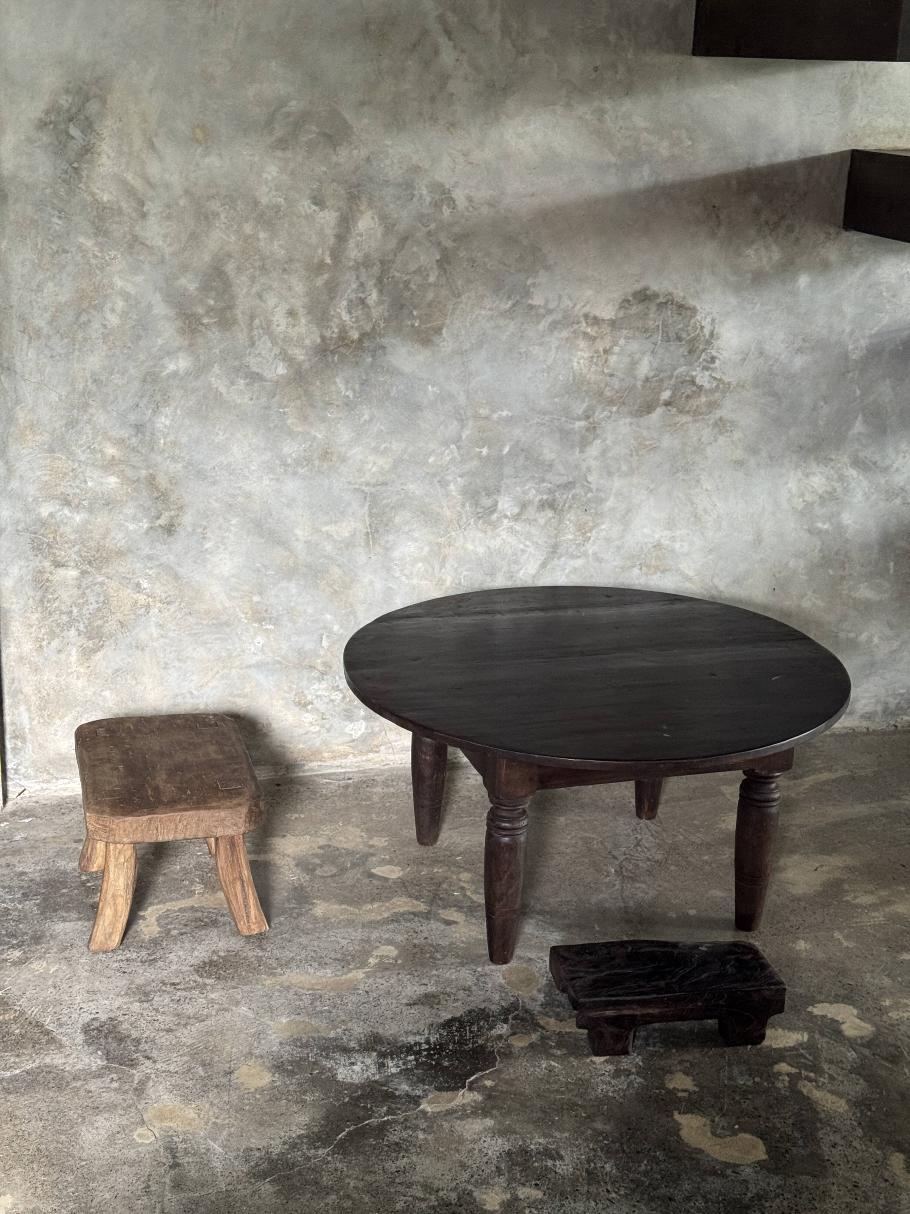 Antique round coffee table in Indonesian teak with turned legs.
