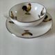 Cup and saucer in porcelain decorated with roosters and hens.