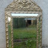 Miroir ancien à pare-closes en laiton repoussé doré 72 x 42 cm