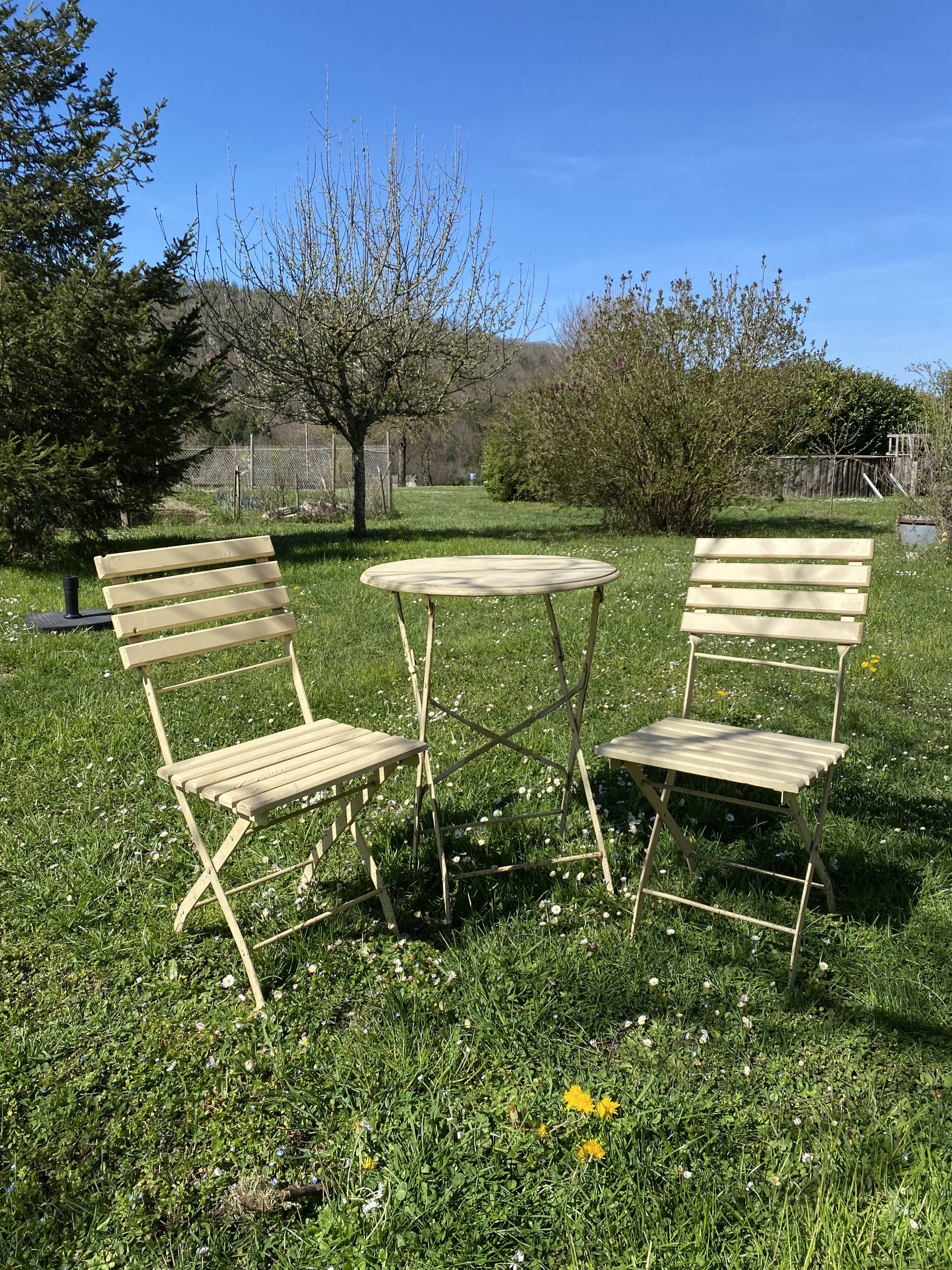 Table et 2 chaises de jardin en métal et bois beige marquées "Bistrot Paris"
