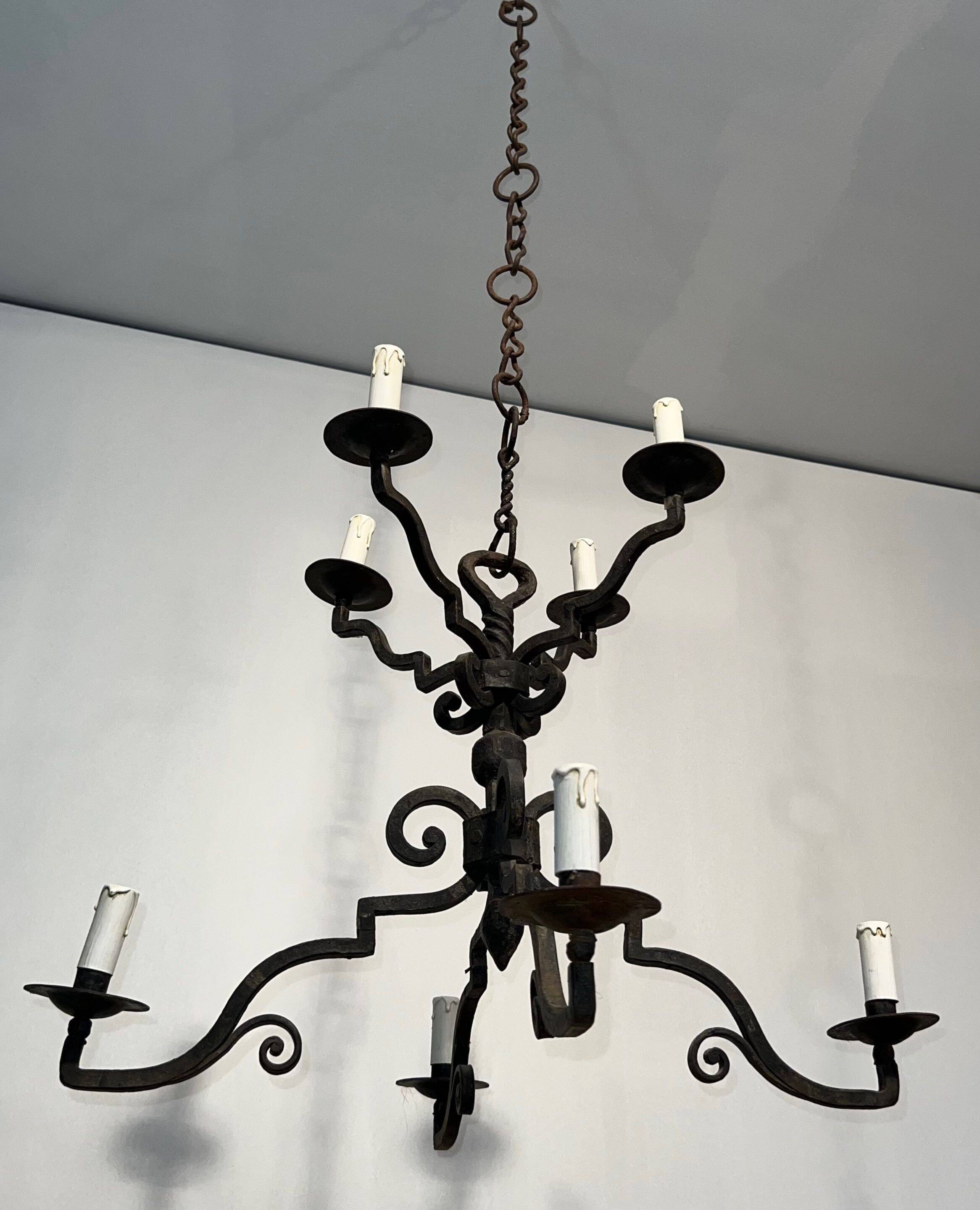 Two-tiered wrought iron chandelier with eight light arms in Gothic style.