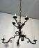 Two-tiered wrought iron chandelier with eight light arms in Gothic style.