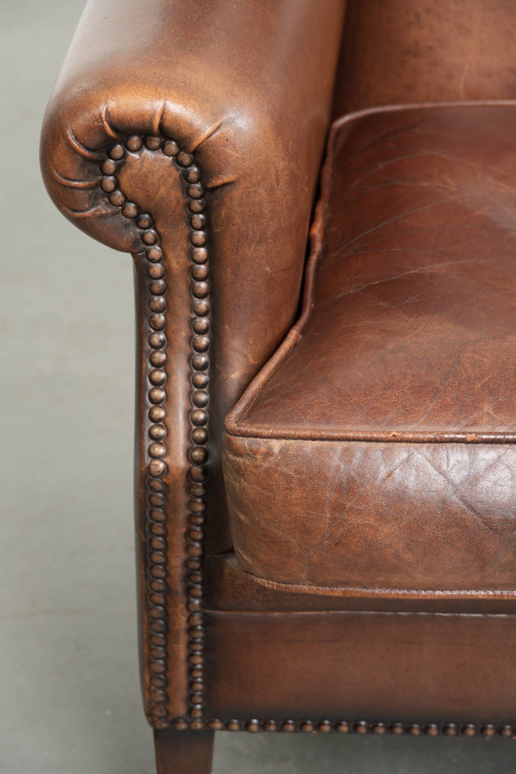 Subtle dark brown sheepskin wingback armchair with a timeless look subtle