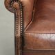 Subtle dark brown sheepskin wingback armchair with a timeless look subtle