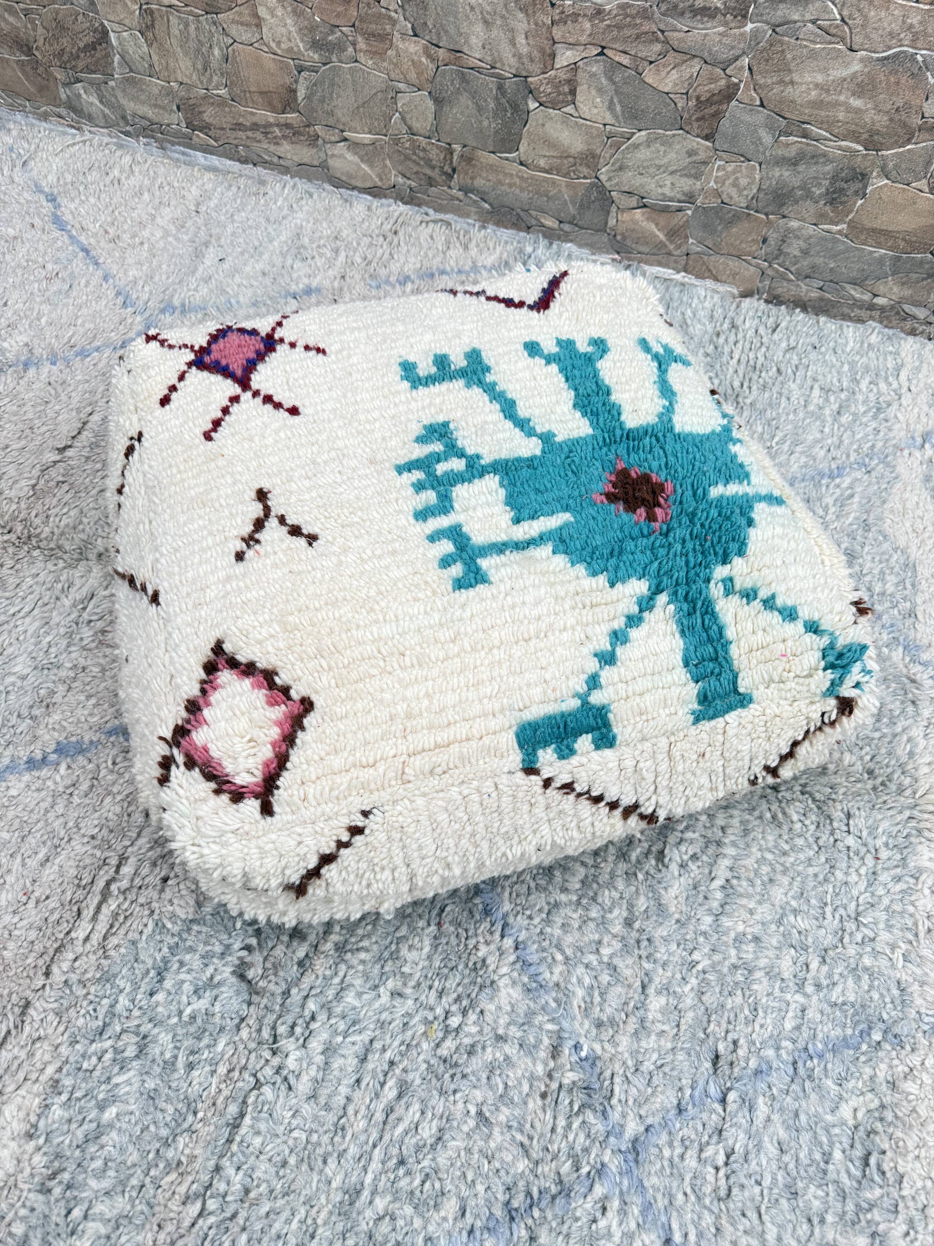 Berber floor pouf: Handwoven Moroccan wool cushion.