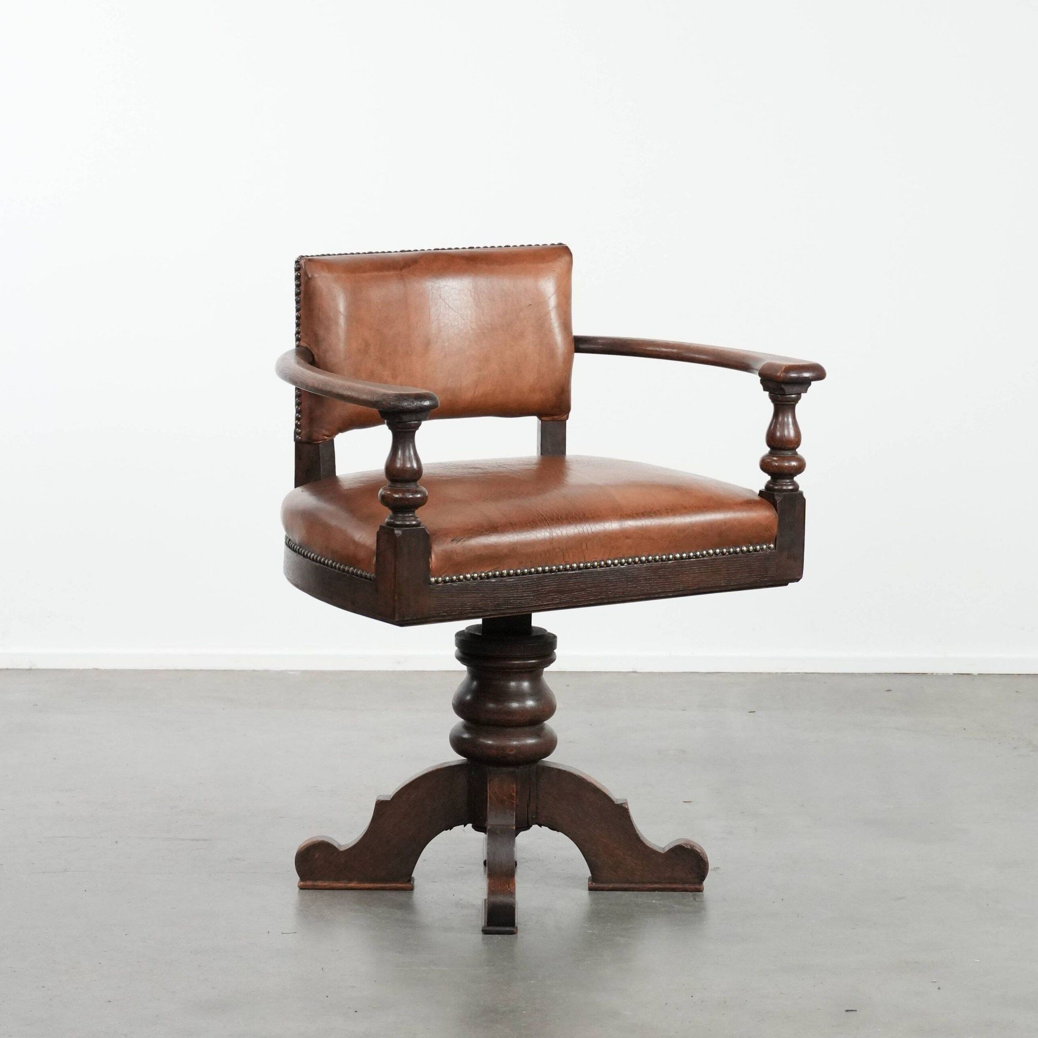 Elegant antique sheepskin leather desk chair with a heavy wooden frame