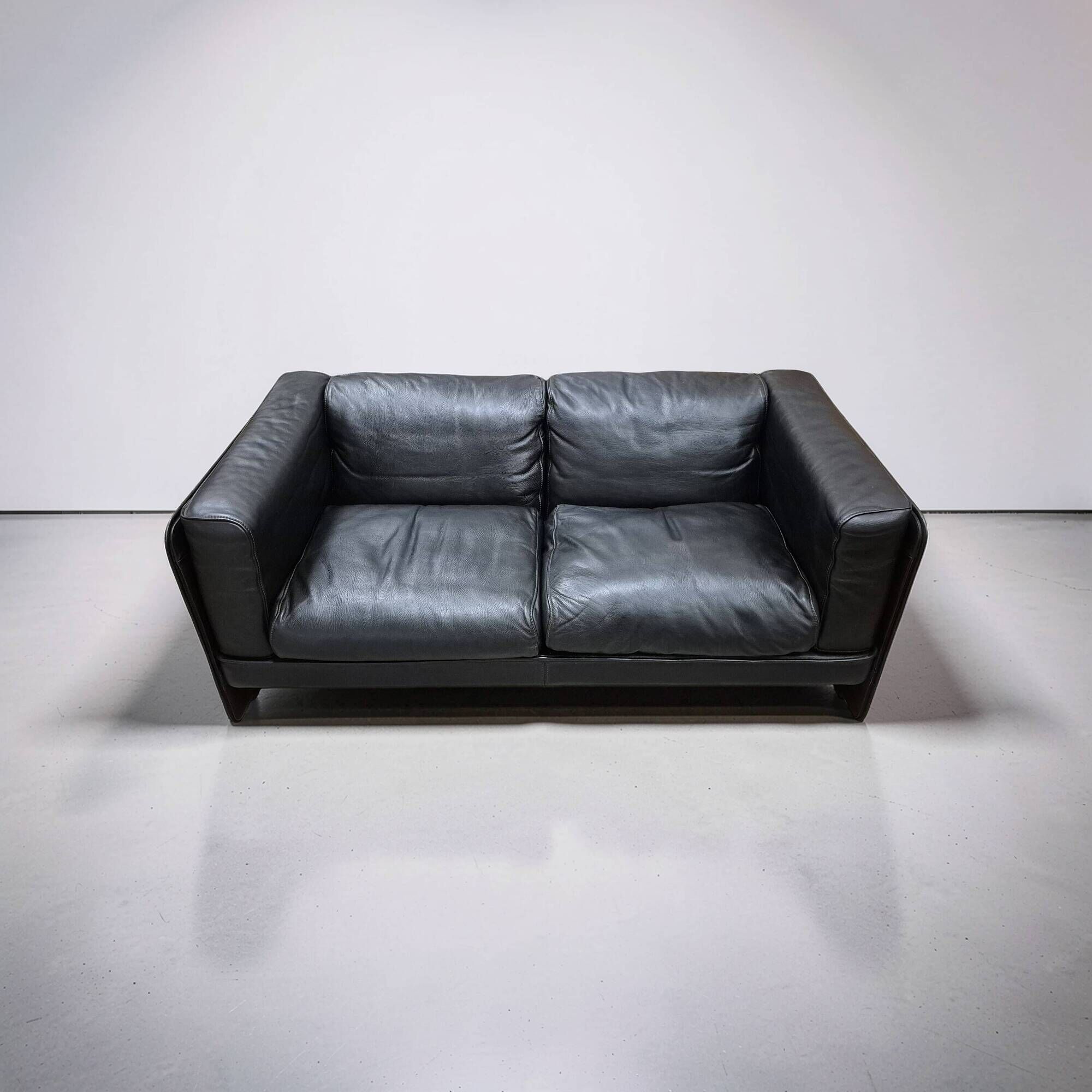 Two-seater sofa in black leather, designed by Tito Agnoli for Poltrona Frau, Italy, 1980s