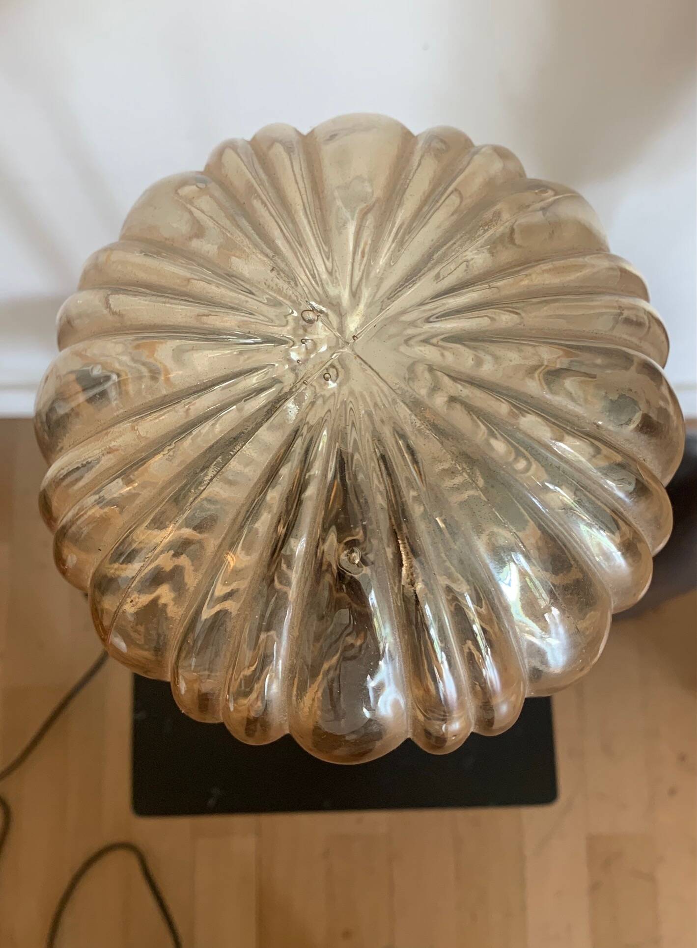 Table lamp with a golden striated globe and a golden base