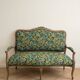 Louis XV bench reupholstered with a green tropical pattern.