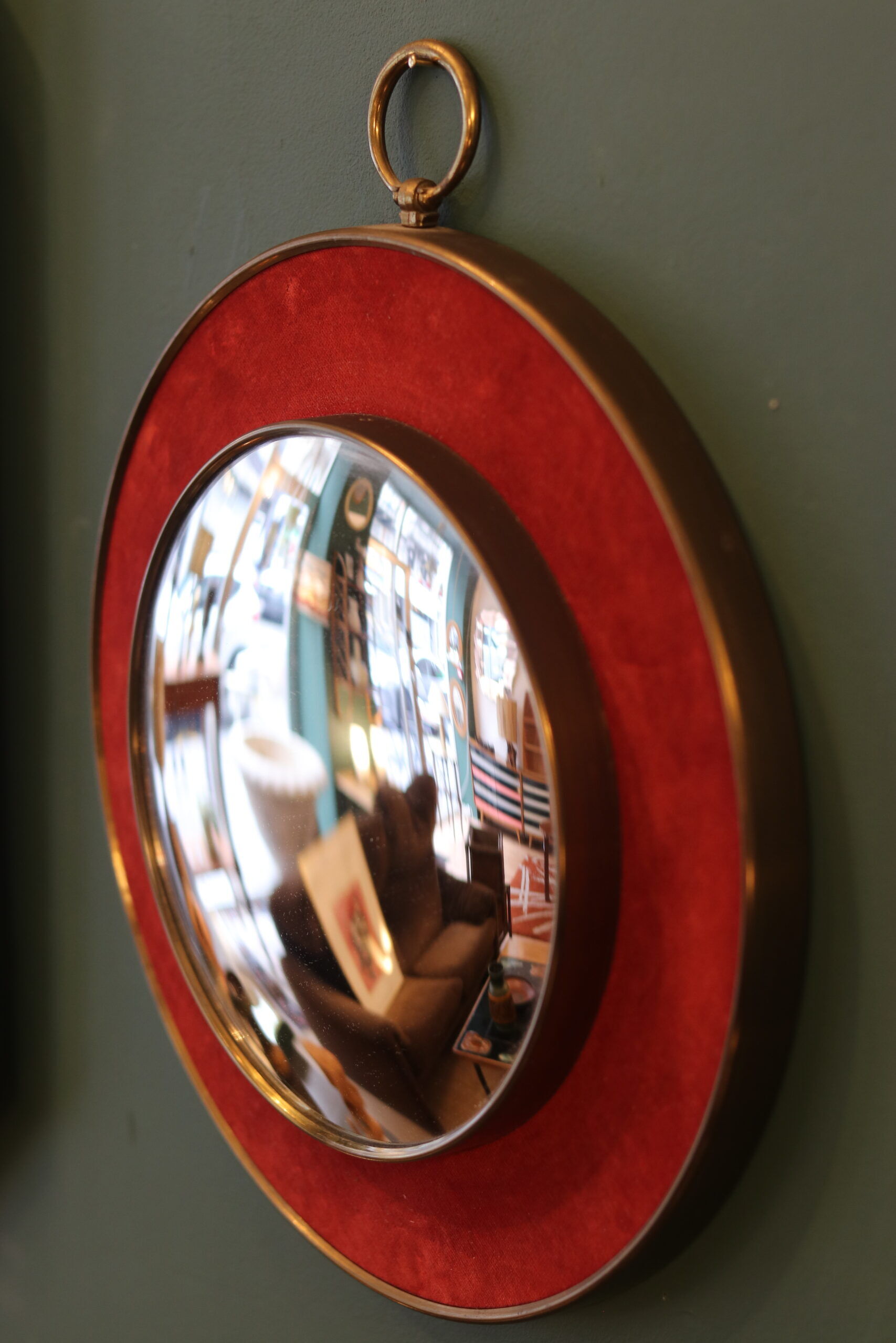 Witch's eye mirror in brass and red velvet