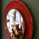 Witch's eye mirror in brass and red velvet