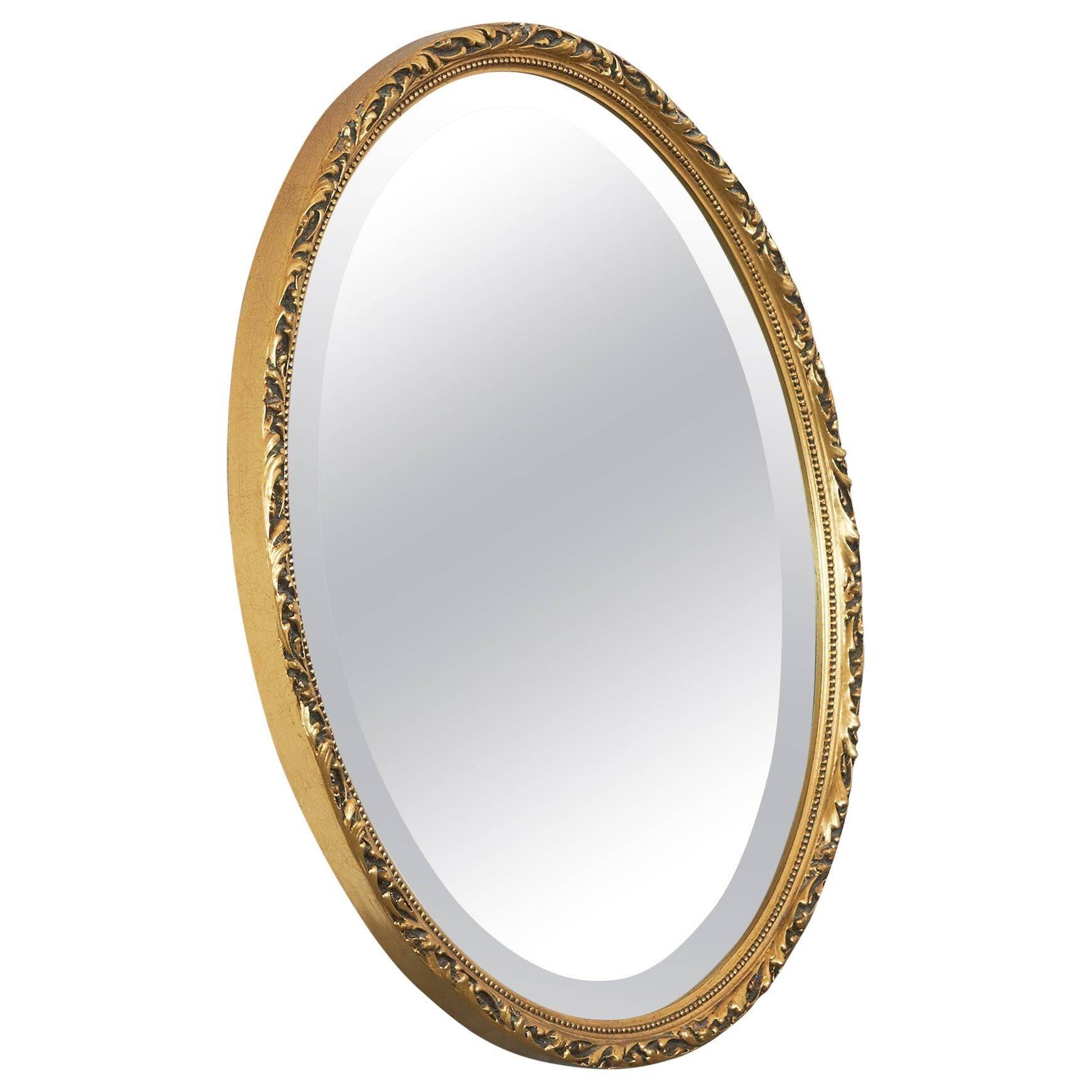 Oval mirror with gilded wood from the 1960s.