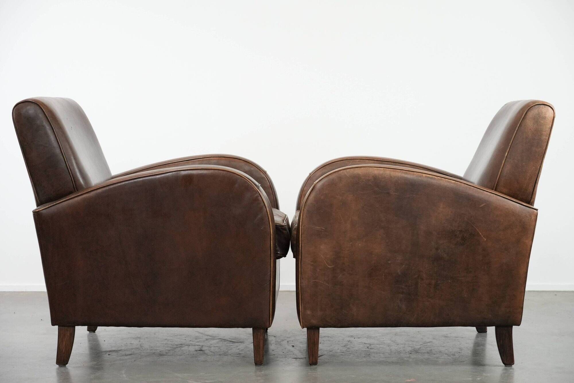 Elegant set of two sheepskin leather armchairs with beautiful round shapes