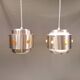 Two Space-Age hanging lamps, in silver-coloured aluminium with orange prisms.