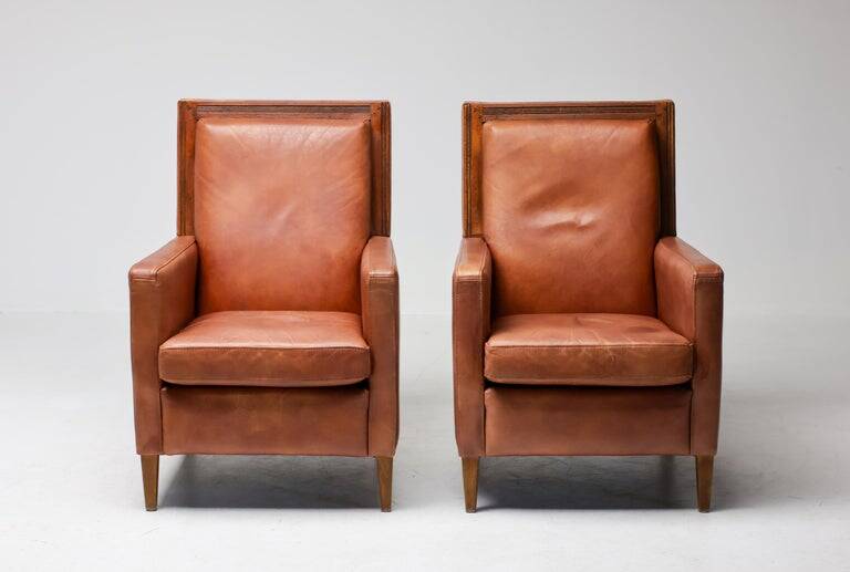 Pair of Art Deco armchairs in brown leather and teak, Netherlands, 1970s.