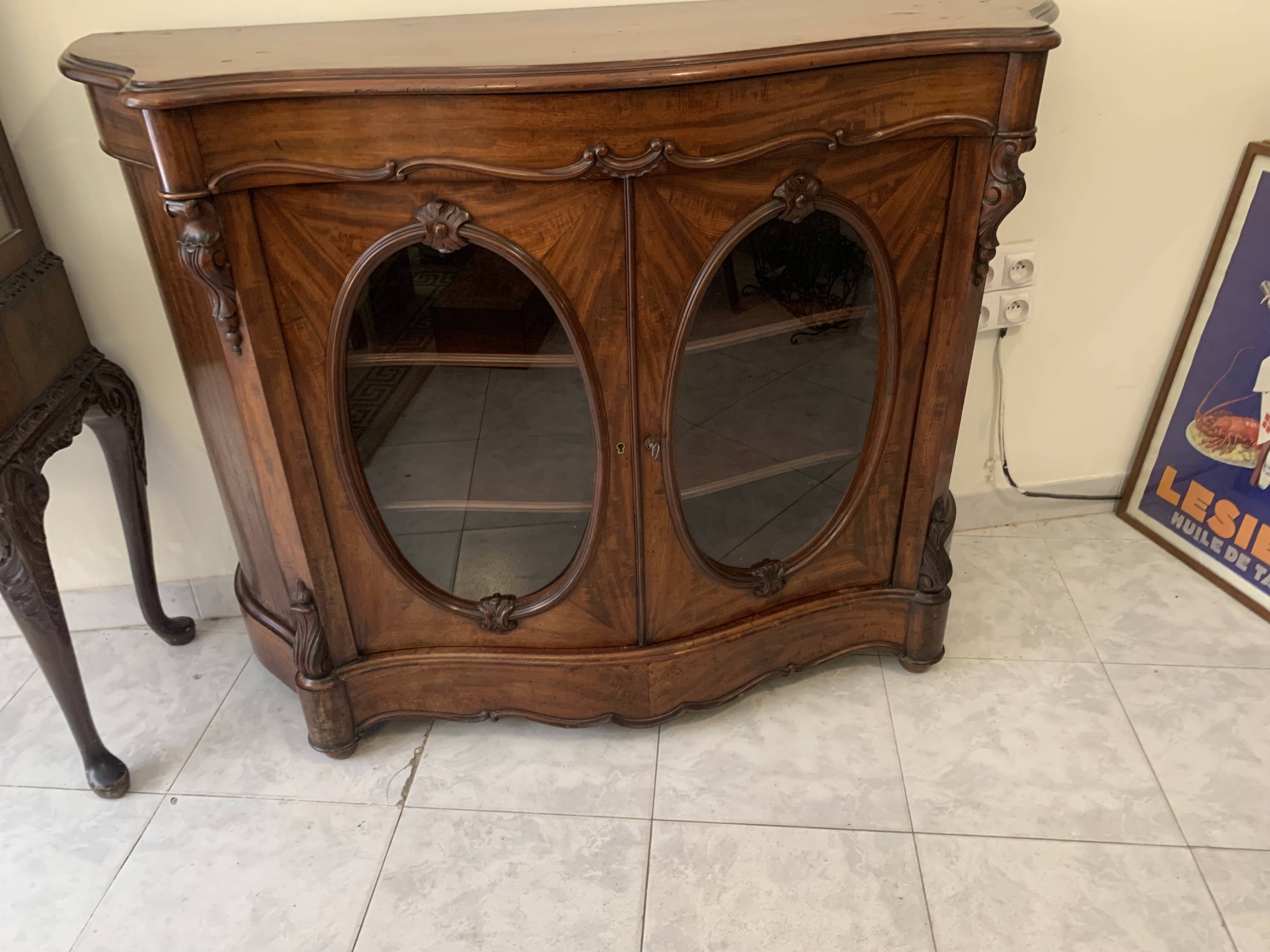 Curved mahogany display cabinet from the Napoleon III period. It has two doors and two shelves.