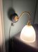 Antique wall sconce in brass and draped glass.