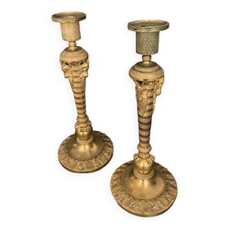 Pair of candlesticks early nineteenth in gilded bronze decorated with rams' heads