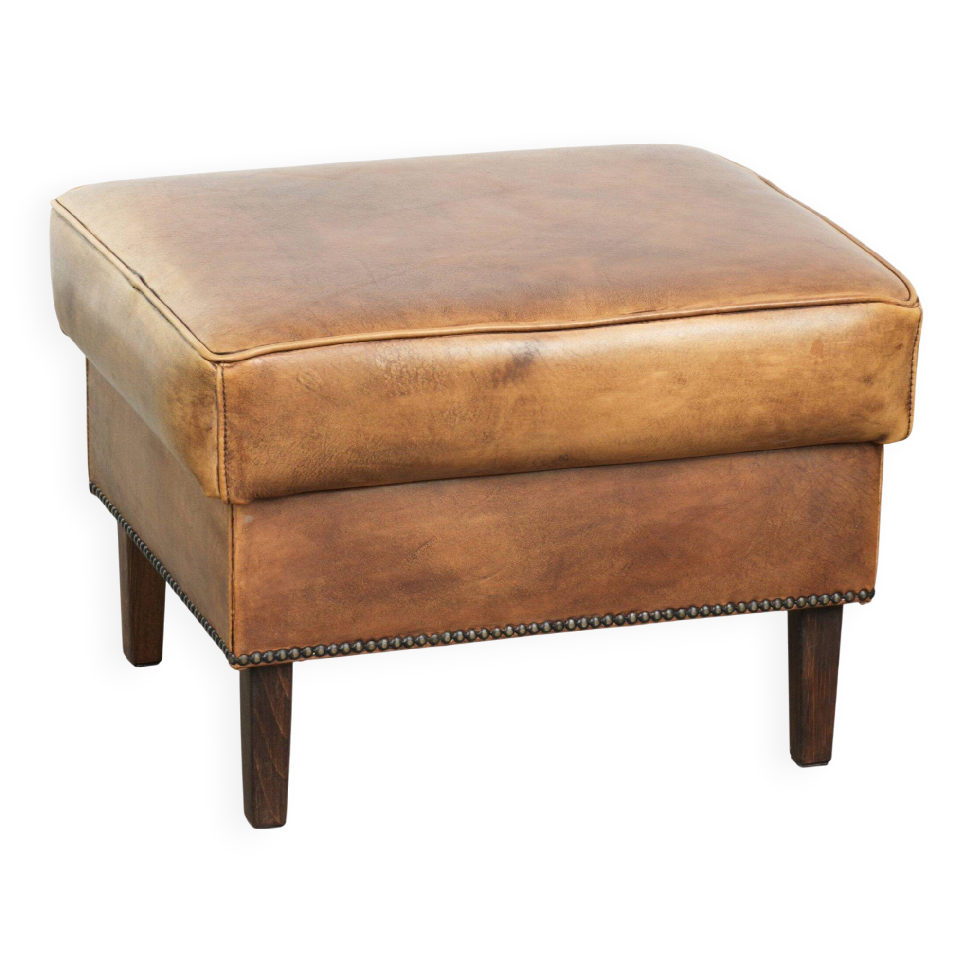 Cowhide ottoman with a beautiful patina finished with decorative nails