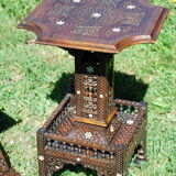 A folding chair and a carved Syrian table with 19th-century mother-of-pearl inlays.