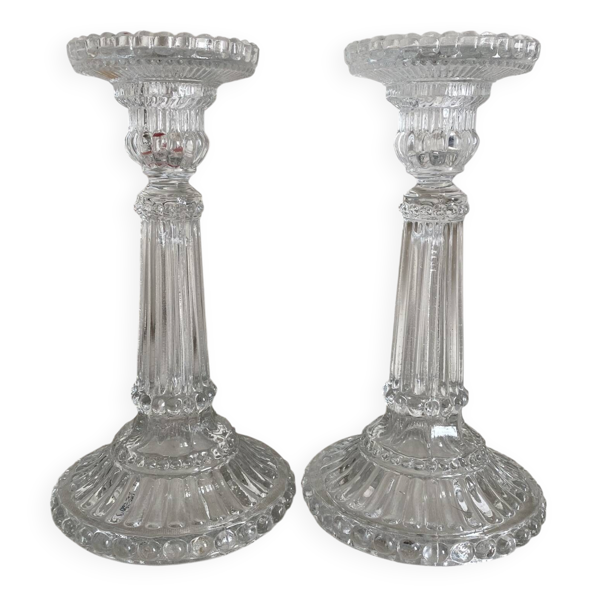 Column candle holders in moulded glass made in France.