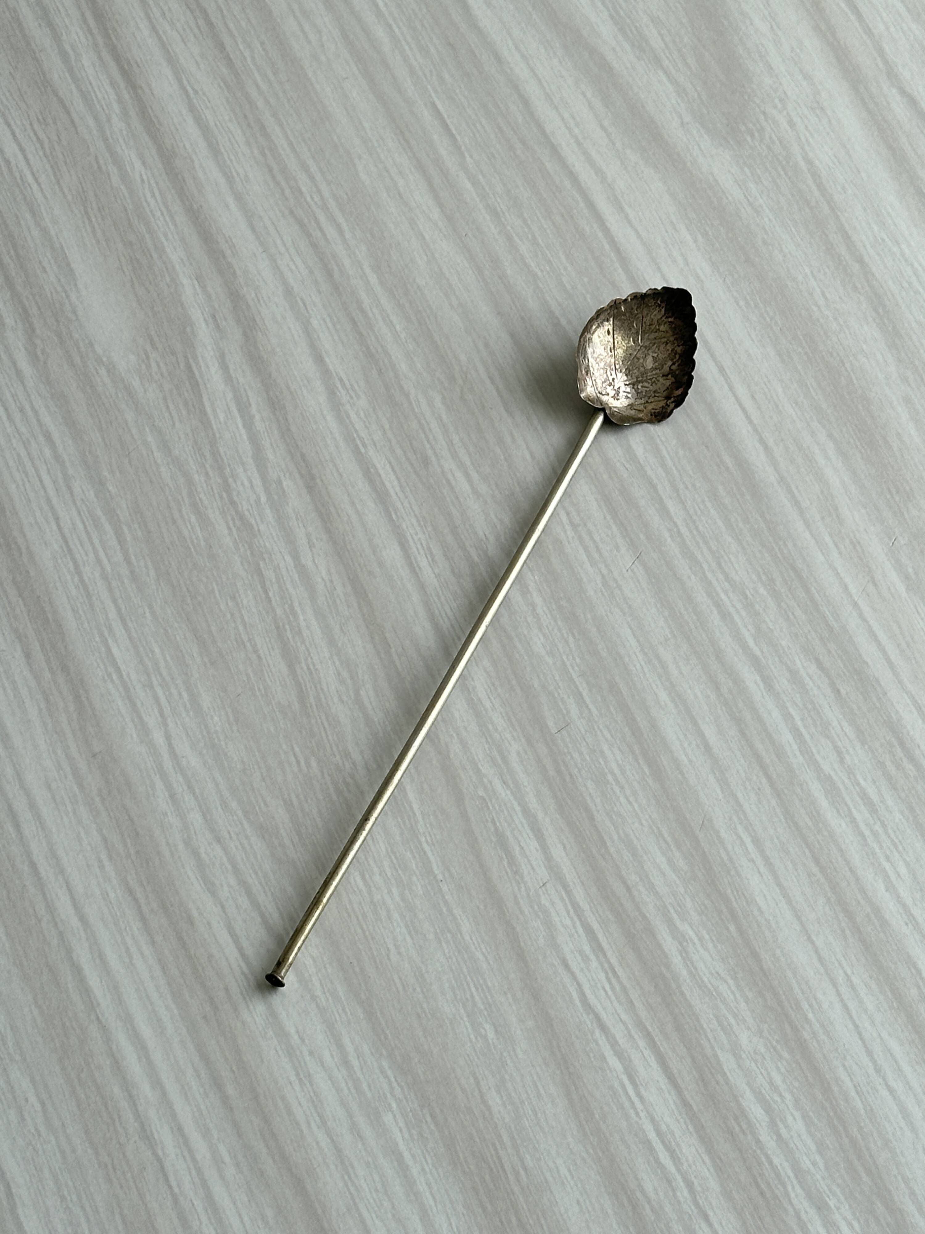 Vintage spoon in old metal, leaf pattern