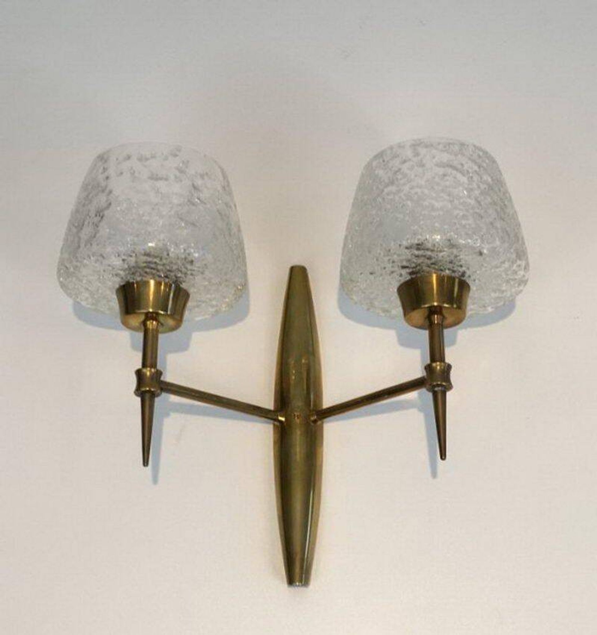 Pair of bronze wall sconces with worked glass reflectors. Stilnovo