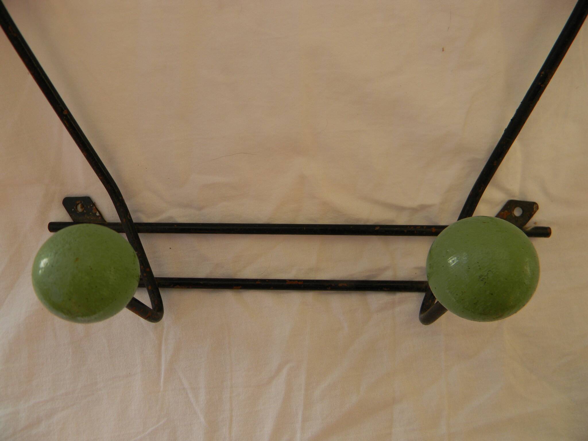 Small wrought iron coat rack with wooden balls.