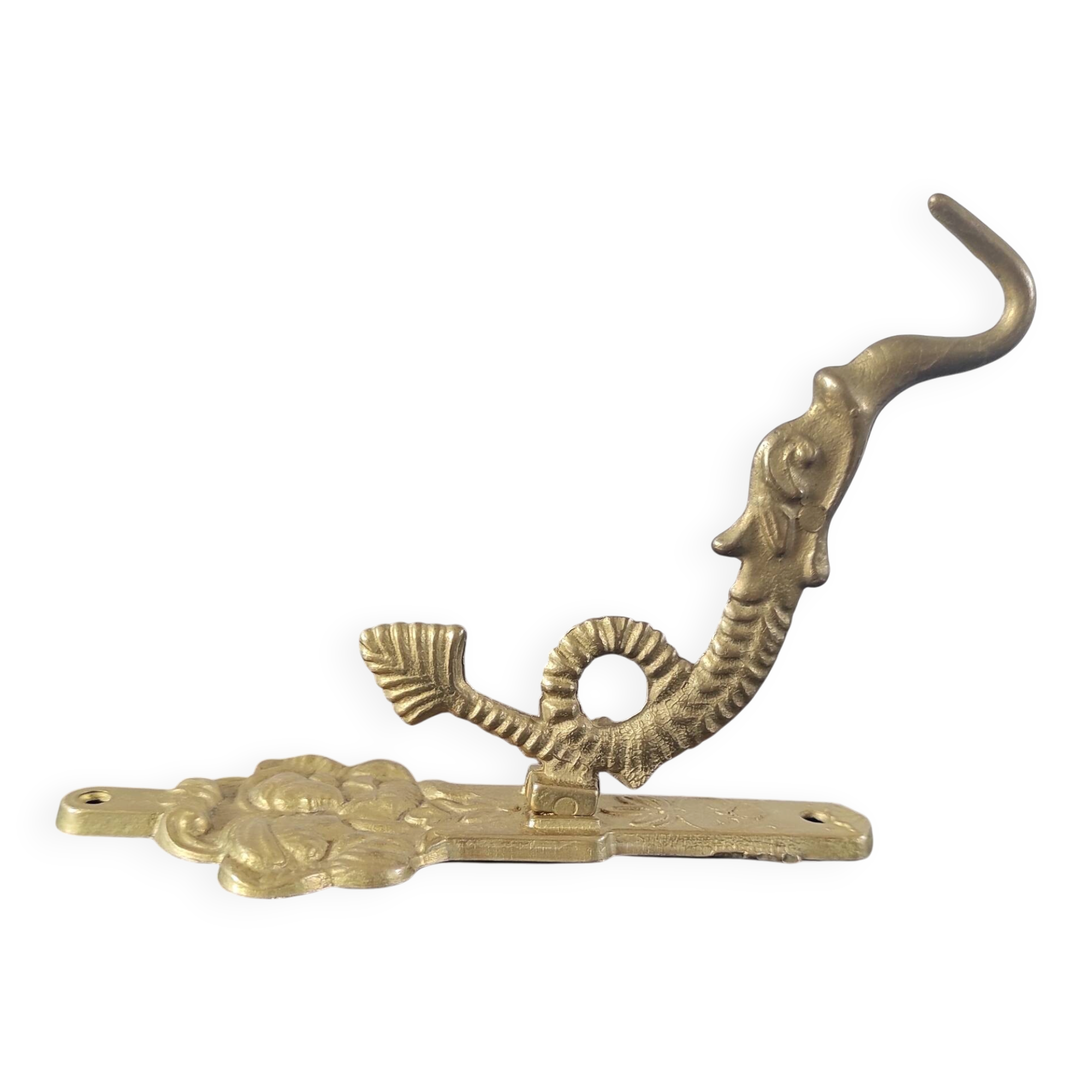 Vintage brass coat hook with marine creature motif and medallion.