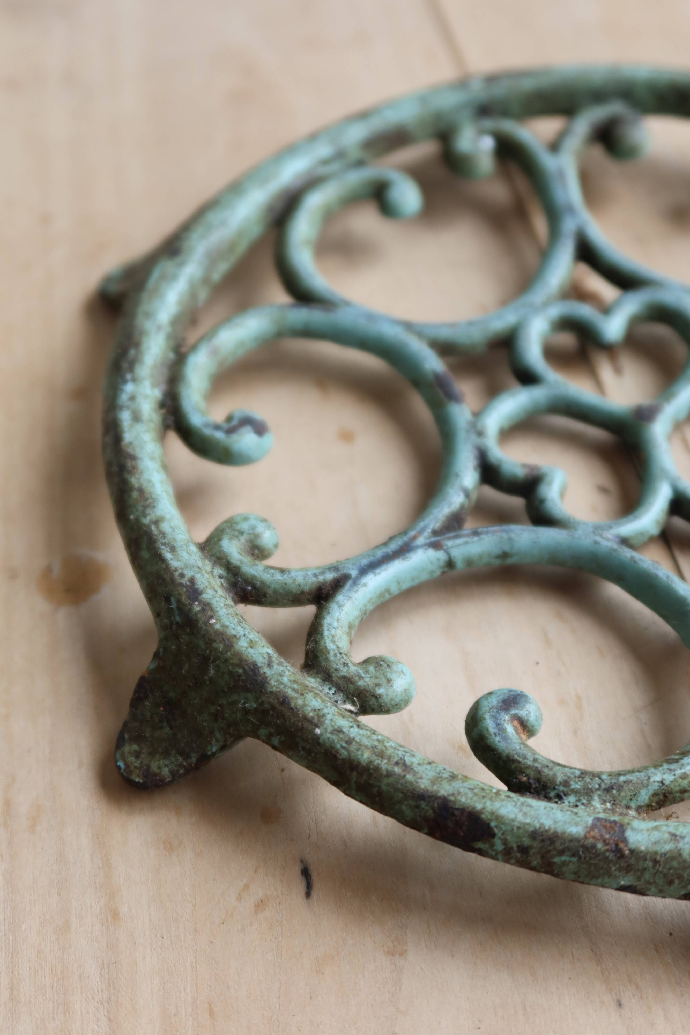 Antique round turquoise cast iron trivet.
