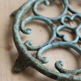 Antique round turquoise cast iron trivet.