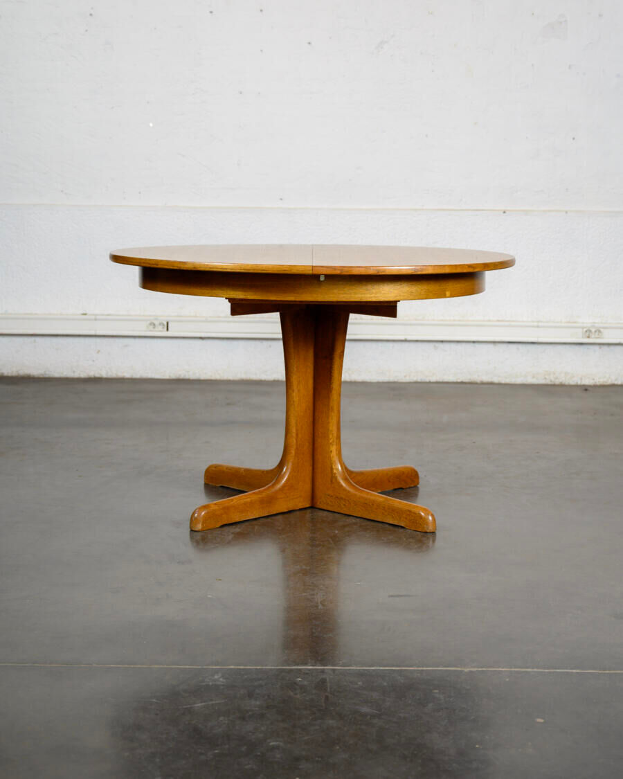 Round teak table with an extension.