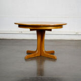 Round teak table with an extension.