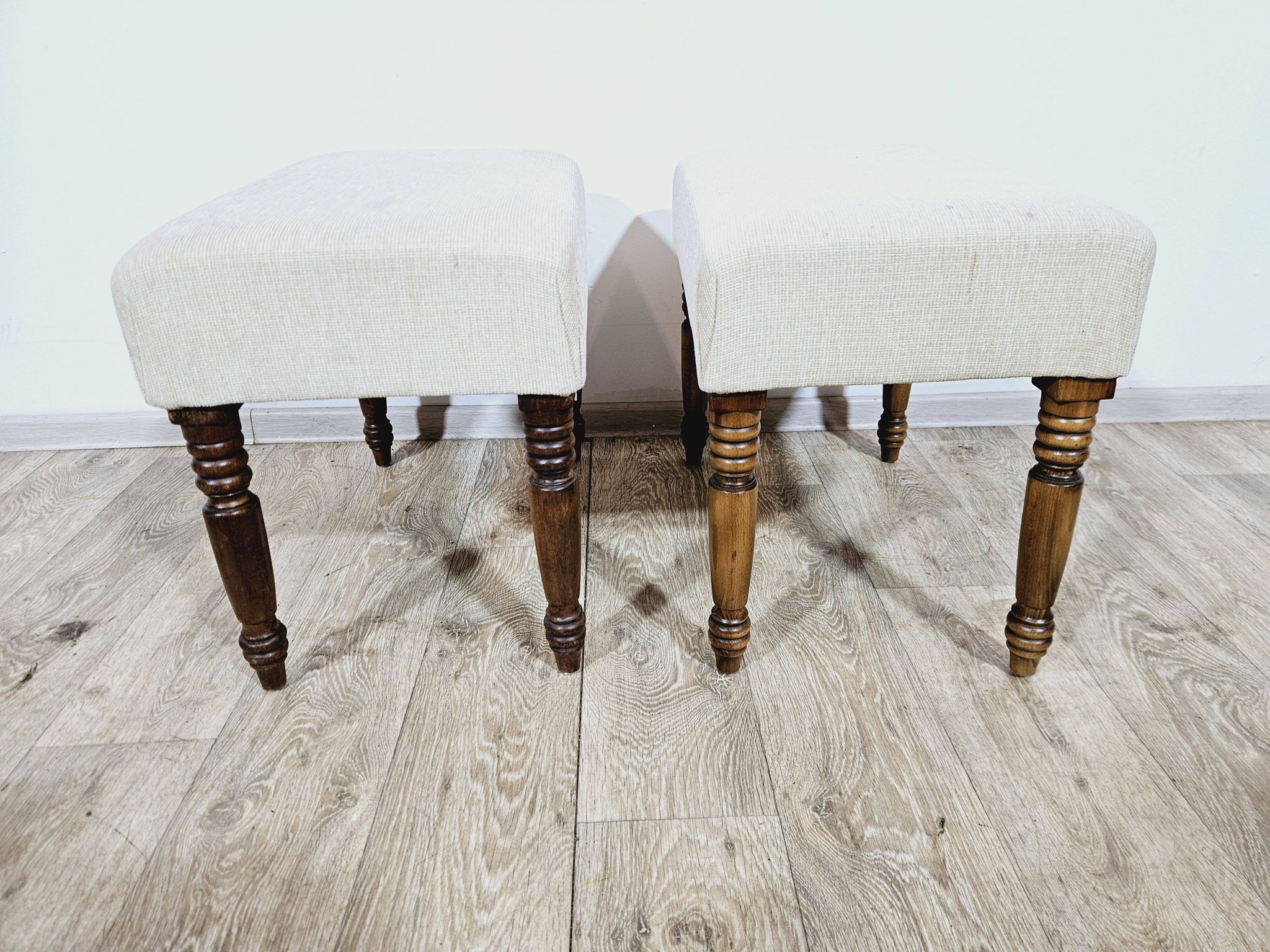 A pair of English upholstered pouffes/footstools from the 19th century