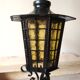 Large hanging lantern in wrought iron and opaque yellow-orange windows