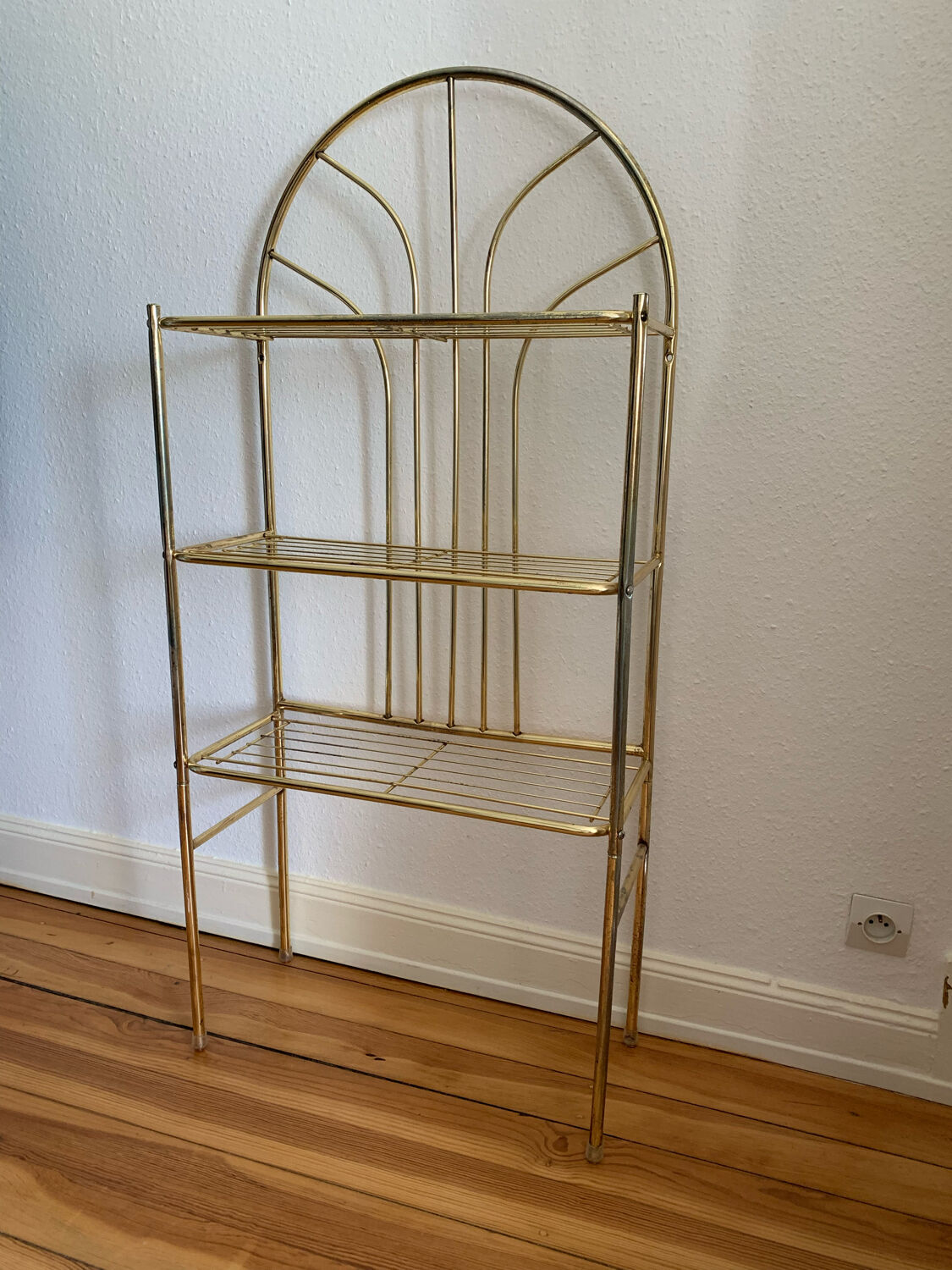 Gilded metal grid shelf in the shape of a vaulted arch