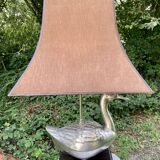 Old vintage lamp representing a duck in silver metal with wooden base