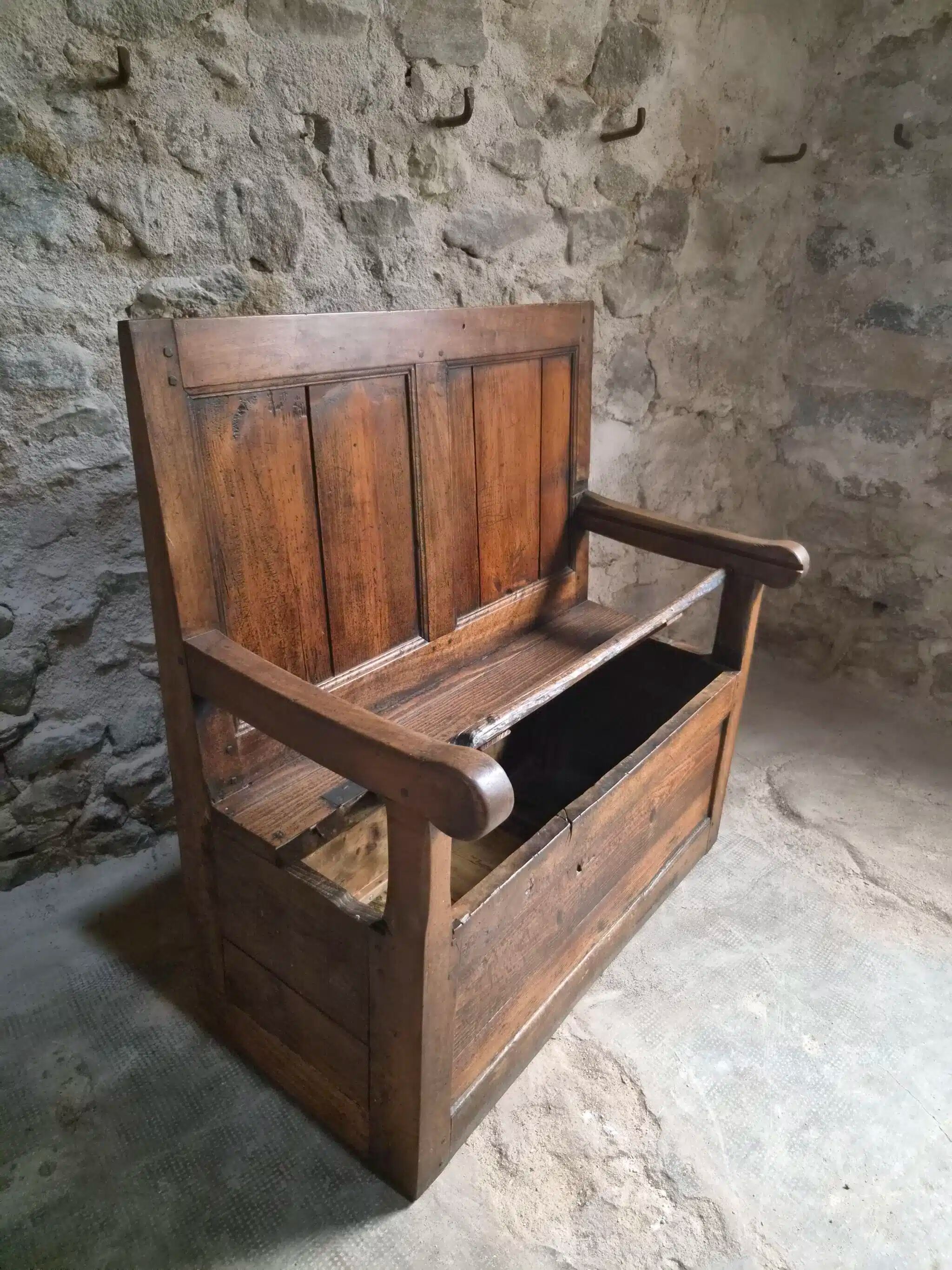 Rustic French antique storage bench from the 18th century in walnut and pine.