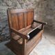 Rustic French antique storage bench from the 18th century in walnut and pine.