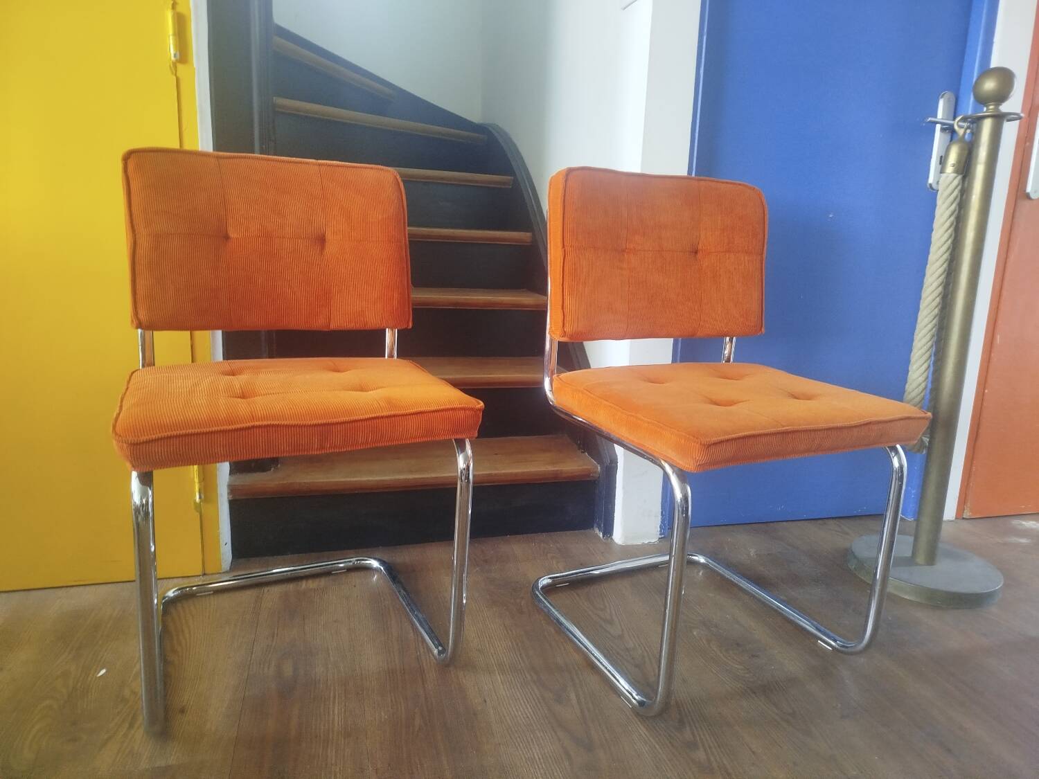 Pair of vintage cantilever chairs in chrome and orange corduroy.