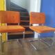 Pair of vintage cantilever chairs in chrome and orange corduroy.