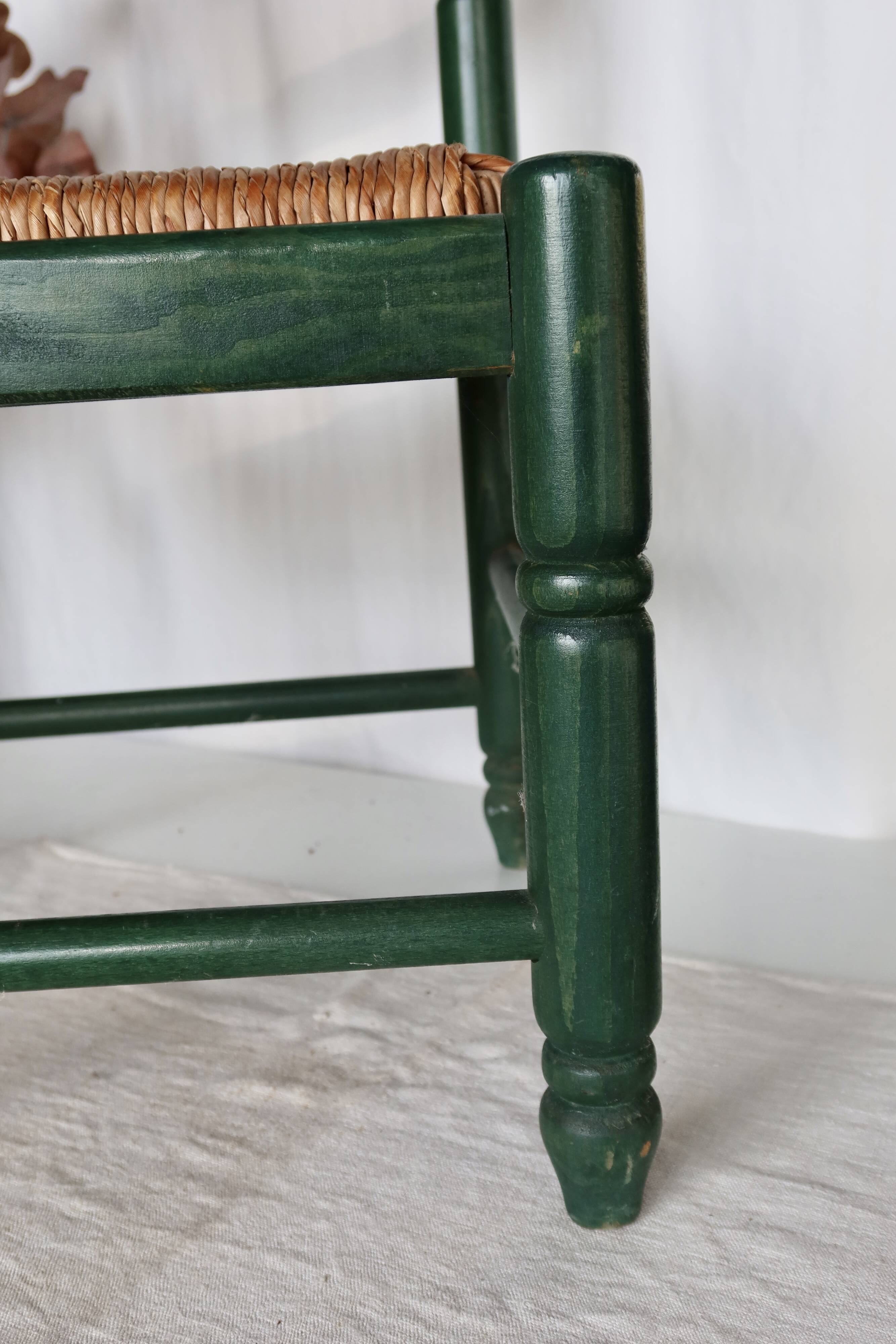 Vintage children's chair in green wood with a woven straw seat
